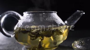 茶叶酿造。 绿茶叶在玻璃壶中旋转。