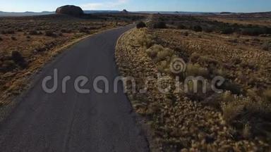 犹他州美丽的沙漠路-无人机空中高清视频飞行沿一条铺好的道路。