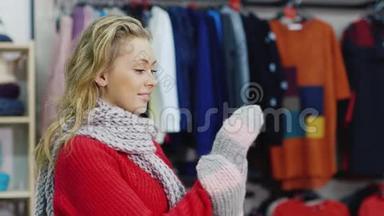 穿红色毛衣的漂亮女人试着用暖和手套。 它<strong>应该</strong>在服装店