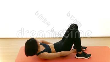 漂亮的泰国亚裔女孩正在做脚跟触摸腹肌腹部<strong>紧缩</strong>在空中有氧运动在白色背景下健身