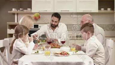 全家人围坐在餐桌旁，吃饭、交流和享受家庭晚餐。