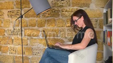 年轻女孩，一个拿着笔记本电脑的女商人，坐在椅子上拿着台灯。学生正在准备考试