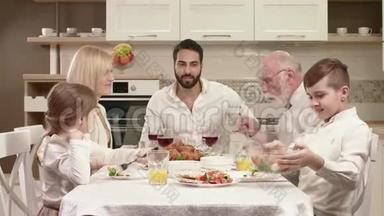 <strong>全家</strong>人围坐在餐桌旁，吃饭、交流和享受家庭晚餐。