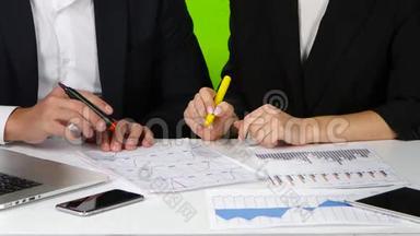 办公室工作人员通过绘制图表来检查他们的数据。 绿色屏幕
