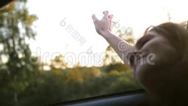 看女人的手在玩风。 把手举起来。 <strong>夏天</strong>坐汽车的年轻女子。 风吹头发。 慢<strong>节奏</strong>