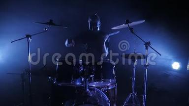 鼓手在舞台上演奏架子鼓. 以慢动作射击。 音乐视频朋克，重金属或摇滚团体。