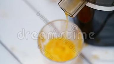 特写镜头，从榨汁机流出新鲜榨出的橙汁倒入一杯.. 从上面看。