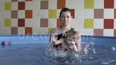 一个<strong>小孩</strong>子和教练在游泳池里<strong>洗澡</strong>