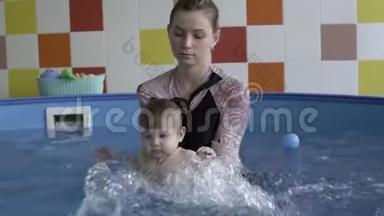 一个小孩子和教练在游泳池里洗澡