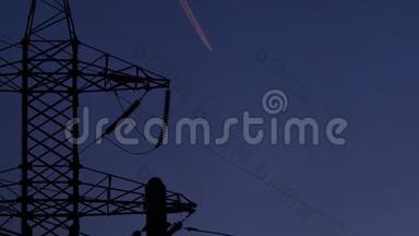高压电塔，来自工厂的黑烟和飞机在夜空中的踪迹。 4k