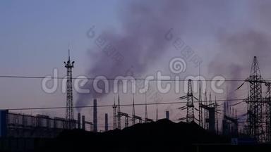工业工厂的空气污染。 管道把黑烟抛向夜空。 吊线和电动支架