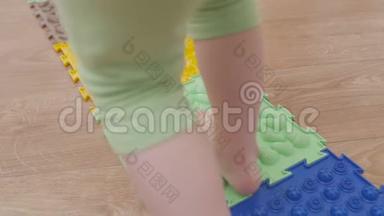 幼儿园里的一个小孩赤脚走在<strong>按摩</strong>垫上，踩在一个带刺的表面上