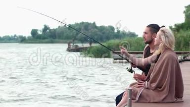 男朋友和女朋友一起在河边钓鱼，湖面上寒冷的早晨，美丽的风景