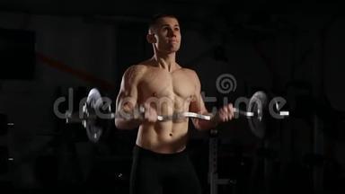 身材魁梧、肌肉发达、在健身房摆姿势、肌肉发达、举重、在黑暗背景下工作的肌肉发达男子