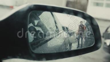 交通和所有权概念-加油站的人在车内加油，从镜子看，下雨天
