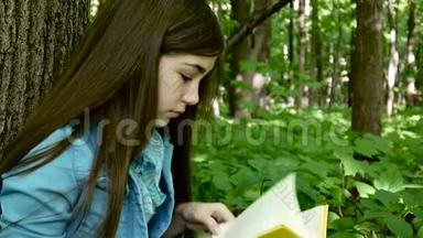 一幅少女认真读<strong>书</strong>、<strong>翻页</strong>的画，春天倚在森林里的树干上，学习