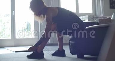 穿着纹身的运动女人在家健身前先系鞋带。 客厅<strong>家政培训</strong>.. 4k慢动作