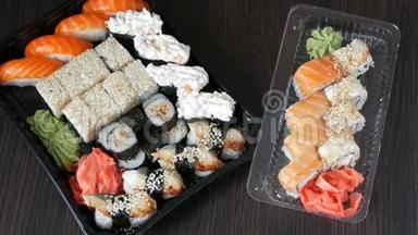 两套大寿司，有很多寿司，卷，肉卷，黑吉里，甘坎。 黑色木桌上的时尚寿司