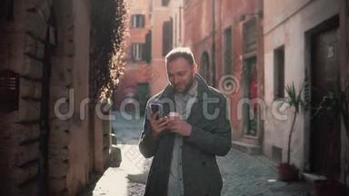 微笑的年轻人早上在城市里散步，用智能手机。 家伙浏览互联网，短信与某人。