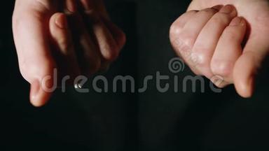 女人展示两个拳头，打开它们，展示张开的手掌中含有维生素。 黑色背景