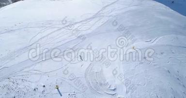 空中跟随滑雪者高山滑雪在冬季雪山滑雪场在晴天。 阿尔卑斯山脉之上