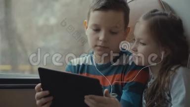 一个年轻的男孩和女孩乘公共汽车穿过<strong>城市</strong>，在电脑平板上<strong>看</strong>电影的特写<strong>镜头</strong>。