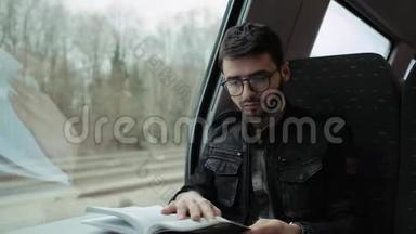 一个小<strong>男孩</strong>在火车上，在桌子上<strong>看书</strong>。 戴眼镜的<strong>男孩</strong>。 4k