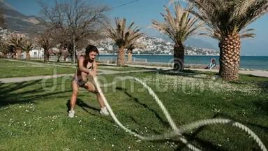女人用两根绳子抱在怀里做运动，快速地站在户外的草地上。