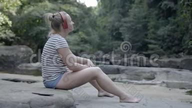 戴耳机的女孩在大自然中听音乐。 别紧张。