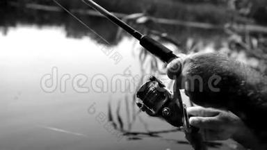 黑白镜头：一个人旋转一个线圈在旋转捕捉鱼
