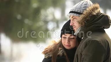 漂亮的一对夫妇花时间在公园里。 他们互<strong>相拥</strong>抱。 下雪天气