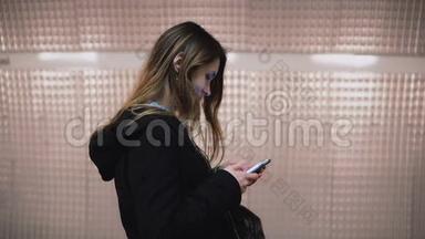 布鲁内特女士站在<strong>地铁</strong>站台<strong>上</strong>使用智能手机。 女孩在等火车时<strong>上</strong>网。