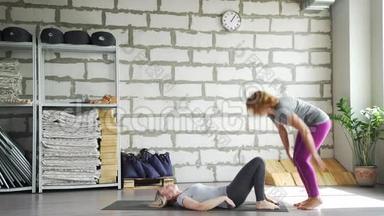 女指导员帮助妇女进行练习。 瑜伽练习