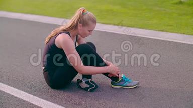 跑完马拉松后，坐在沥青路上疲惫不堪的女人