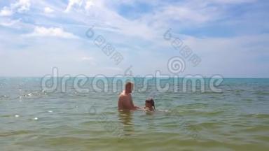 爸爸教女儿在海里游泳。 父亲`关怀理念