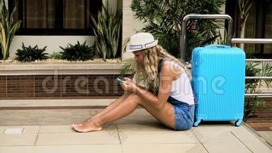 戴着帽子的金发女孩，穿着蓝色包的<strong>工作服</strong>，住在一家带游泳池的热带<strong>酒店</strong>里。 4K