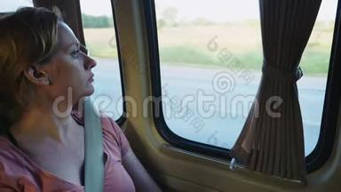 悲伤的女孩骑着公共汽车，<strong>望</strong>着<strong>窗外</strong>。