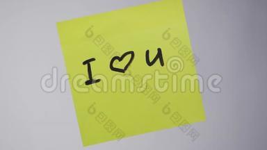 贴纸上的铭文我爱你。 画画`我爱你`心在黄纸上。 铭文我爱你