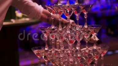 在宴会上，服务员端着一杯香槟在金字塔上用餐. 剪辑。 香槟杯金字塔
