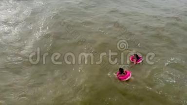 穿着橡皮圈的人在海里的波浪上游泳。 空中录像