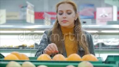 漂亮的年轻漂亮的红发女人在市场上，在超市里买食物、水果、<strong>苹果</strong>。 女孩选择产品
