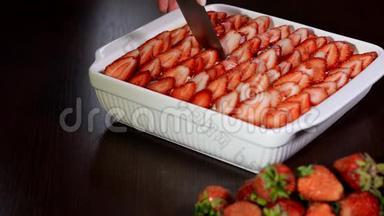 女人用刀切草莓提拉米苏。草莓提拉米苏甜点。