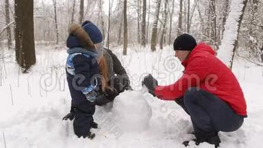 一家人带着孩子在公园堆雪人。