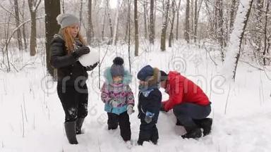 有孩子的小家庭堆雪人。