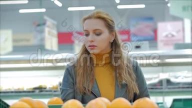 漂亮的年轻漂亮的红发女人在市场上，在超市里买食物、水果、苹果。 女孩选择产品