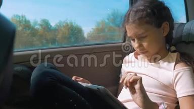 小女孩坐在车里，带着平板电脑，互联网，社交媒体<strong>去旅行</strong>。 汽车概念<strong>旅行</strong>运动运输