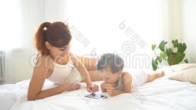 妈妈和宝宝在卧室里看智能手机