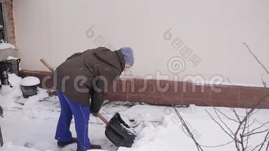 一位老年妇女打<strong>扫房子</strong>附近的雪铲