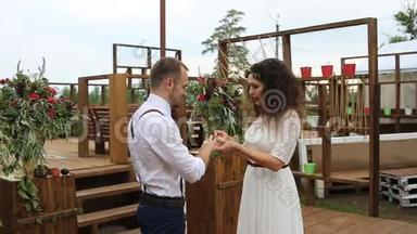 温柔美丽的新娘把结婚戒指戴在新郎`手指上。 概念：婚礼乡村化..