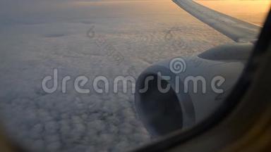 <strong>飞机机翼</strong>通过<strong>飞机</strong>窗口的视图。 日出时在云层上方飞行。